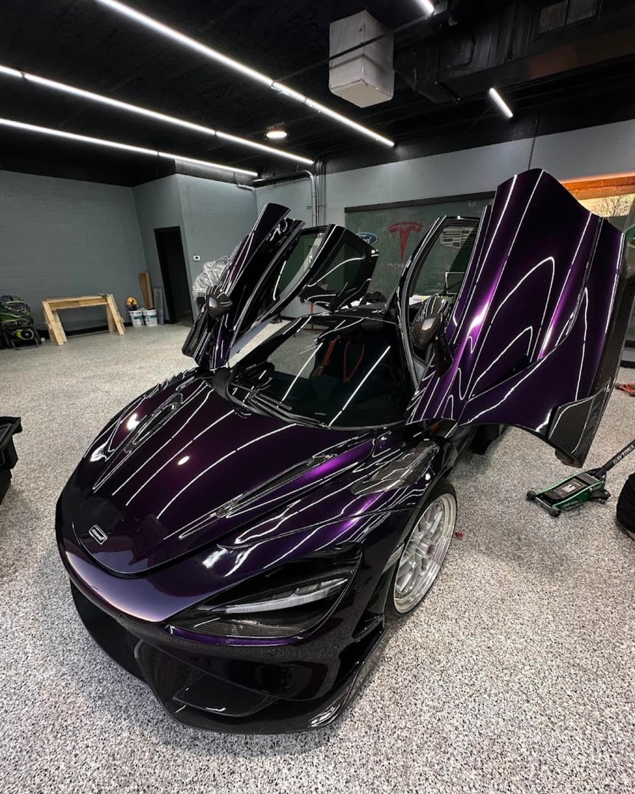 Purple McLaren 720S with its doors up in the Dallas Tint Shop bay