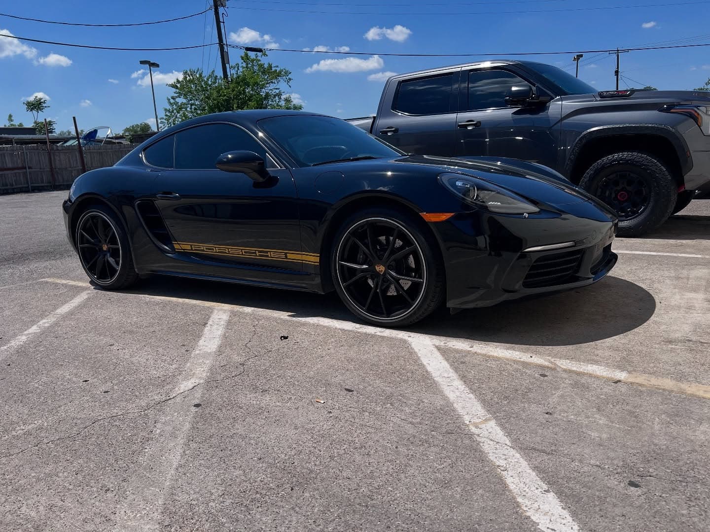 Black Porsche 718 Cayman with custom satin gold decals
